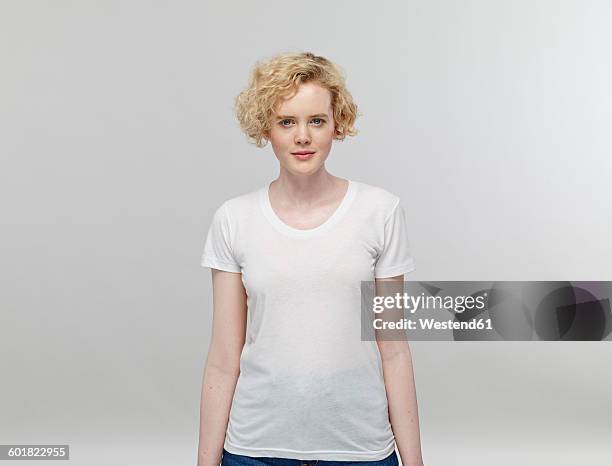 portrait of blond woman wearing white t-shirt in front of grey background - caucasian ethnicity stock pictures, royalty-free photos & images