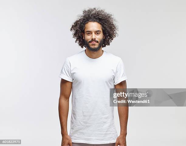 portrait of bearded young man with curly brown hair wearing white t-shirt - space man stockfoto's en -beelden
