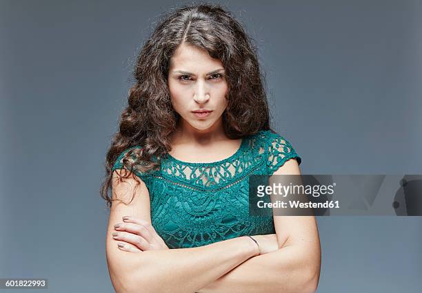 portrait of angry young woman with crossed arms - angry women stock pictures, royalty-free photos & images
