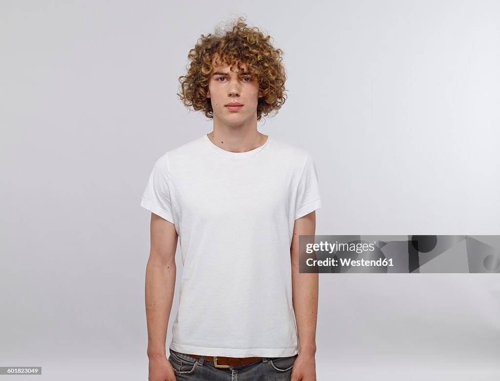 Portrait of young man with curly blond hair wearing white t-shirt