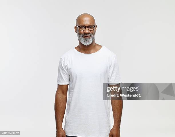 portrait of smiling bald man with beard wearing spectacles and white t-shirt - grey shirt ストックフォトと画像