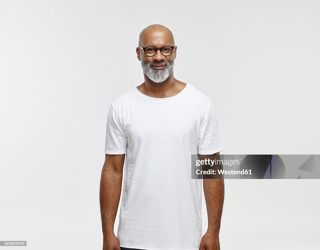 Portrait of smiling bald man with beard wearing spectacles and white t-shirt