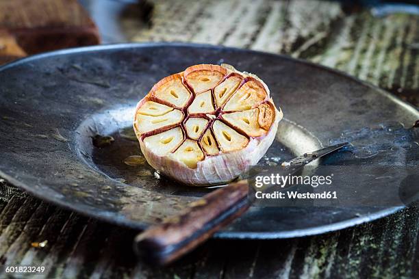 roasted garlic on plate, knife - knoblauch stock-fotos und bilder