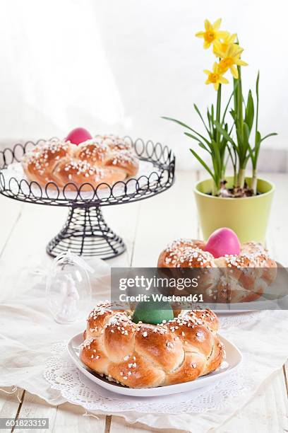 braided easter bread with coloured eggs and daffodil - geflochtenes brot stock-fotos und bilder