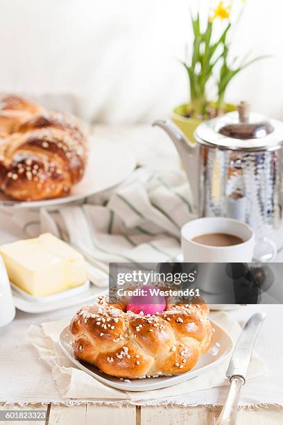 braided easter bread with pink egg, daffodil, coffee and butter - geflochtenes brot stock-fotos und bilder