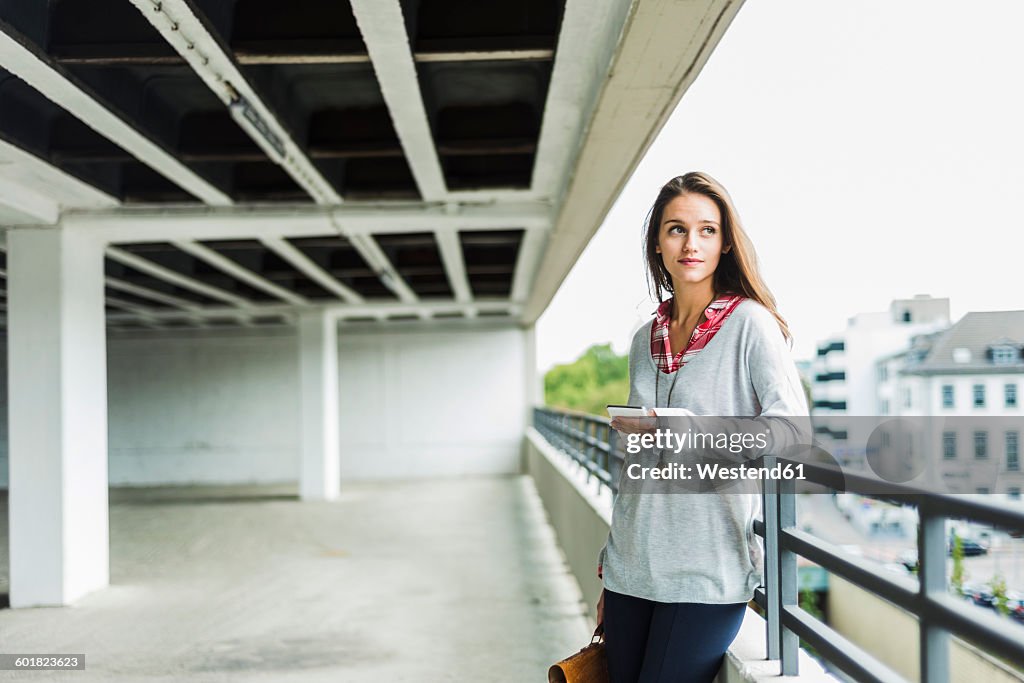 Young woman with cell phone in parking garage