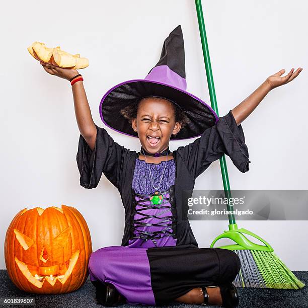 girl dressed in witch costume with pumpkin at halloween - naughty halloween stock pictures, royalty-free photos & images