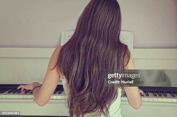 rear view of girl playing the piano - e girls stock pictures, royalty-free photos & images