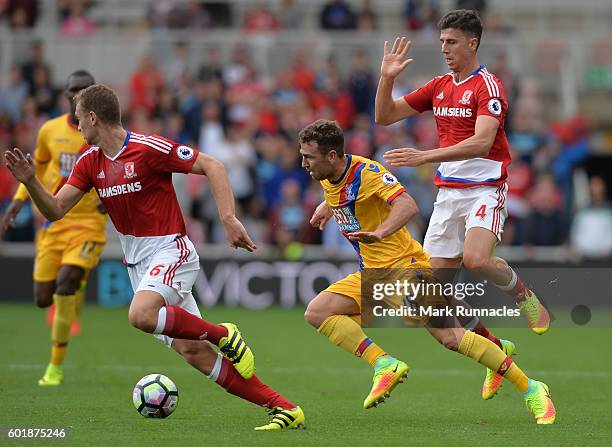 James McArthur of Crystal Palace is tackled by Daniel Ayala and Ben Gibson of Middlesbrough during the Premier League match between Middlesbrough FC...