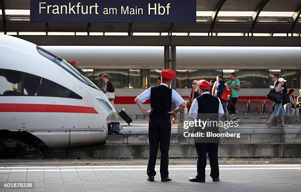 Employees stand on a platform near to a stationary InterCity Express train, operated by Deutsche Bahn AG, at Frankfurt Central Railway Station in...