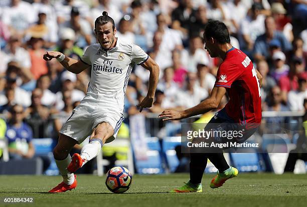 Gareth Bale of Real Madrid is challenged by Unai Garcia of Osasuna during the La Liga match between Real Madrid CF and CA Osasuna at Estadio Santiago...