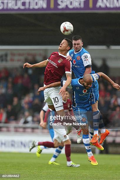 Alex Revell of Northampton Town contests the ball with Adam Chambers and Kevin Toner of Walsall during the Sky Bet League One match between...