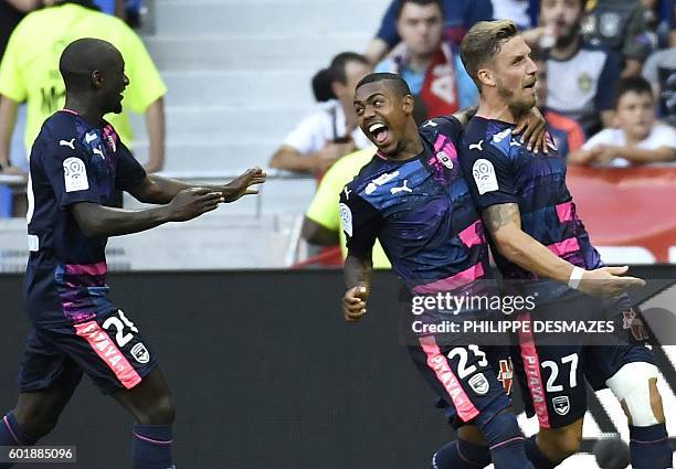 Bordeaux's French defender Gregory Sertic is congratulated by teammates Youssouf Sabaly and Malcom after scoring a goal during the French L1 football...