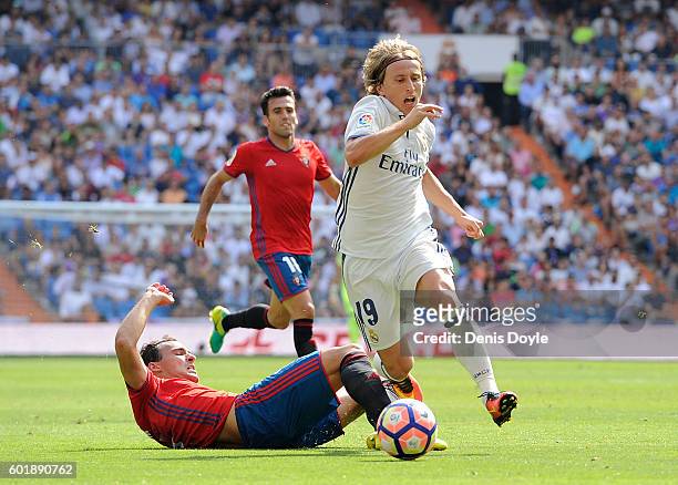 Luka Modric of Real Madrid is fouled by Unai Garcia of CA Osasuna during the La Liga match between Real Madrid CF and CA Osasuna at Estadio Santiago...