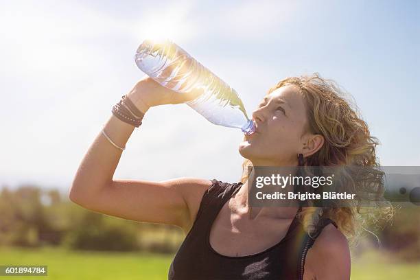 woman drinking water - junge frau allein stock-fotos und bilder