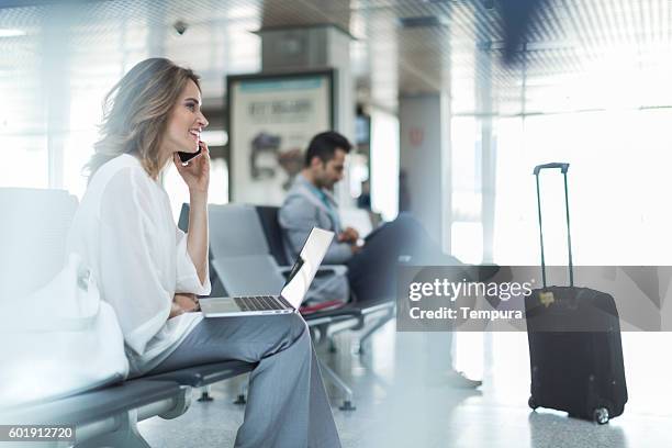 working and using phone while waiting on departure gate. - continuity stock pictures, royalty-free photos & images