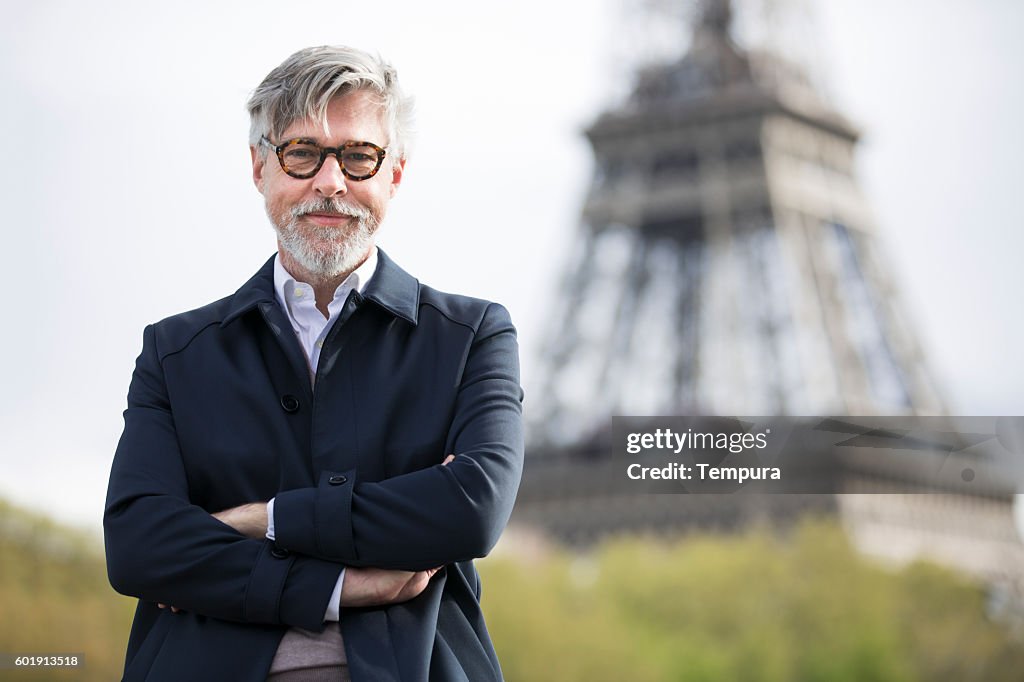 Middle aged man traveling near the eiffel tower.