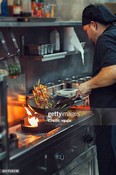preparing meal in a wok. - wok stockfoto's en -beelden