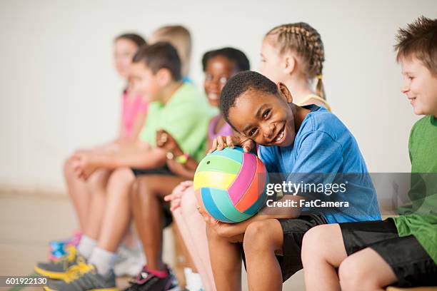 sitting on the bench before the game - school gymnasium stockfoto's en -beelden