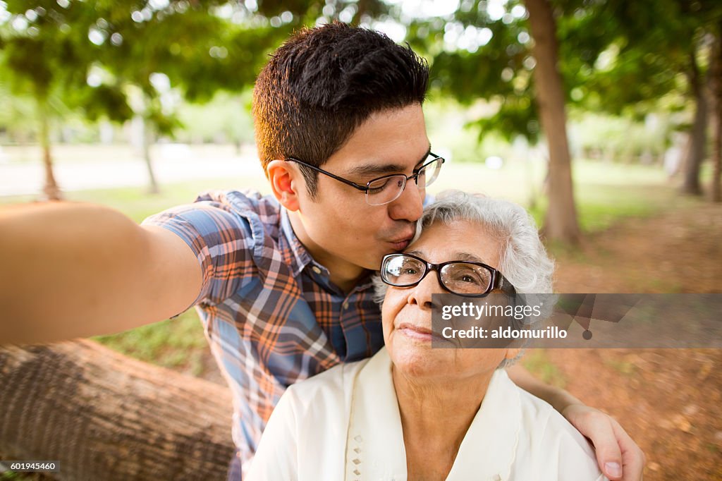 Selfie of grandson kissing grandmother on forehead