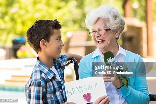 happy grandmother receives gift from her grandson - beautiful granny 個照片及圖片檔