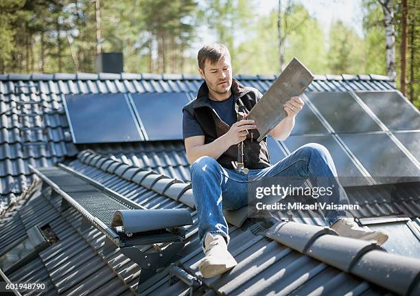 handyman constructing his own home - daktegel stockfoto's en -beelden