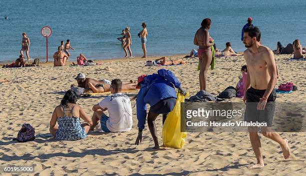 Beachgoers and a beach cleaner at work in Praia da Duquesa on September 09, 2016 in Cascais, Portugal. Although active all year round, Portuguese...