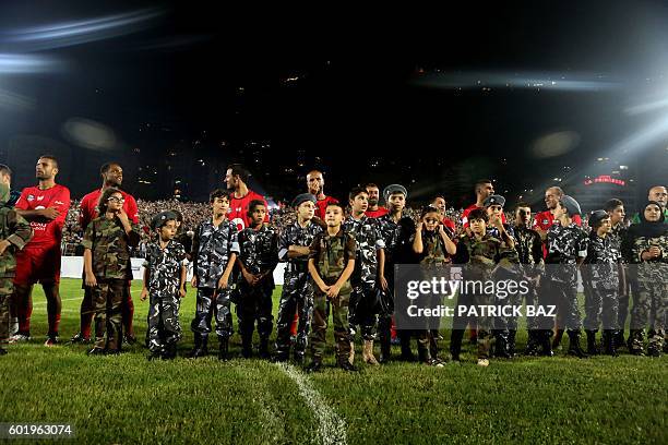 Veteran Lebanese football players pose at the Fouad Chehab stadium in the northern Lebanese coastal town of Jounieh with children cladded in uniforms...