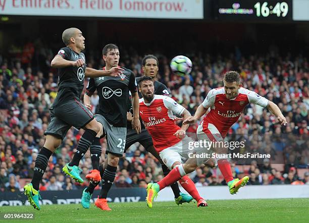 Shkodran Mustafi of Arsenal challenged by Oriol Romeu and Jose Fonte of Southampton during the Premier League match between Arsenal and Southampton...