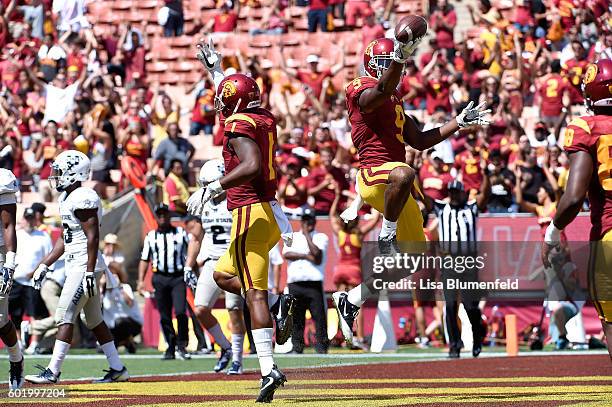 JuJu Smith-Schuster of the USC Trojans celebrates with teammate Darreus Rogers after scoring a touchdown in the 4th quarter against the Utah State...