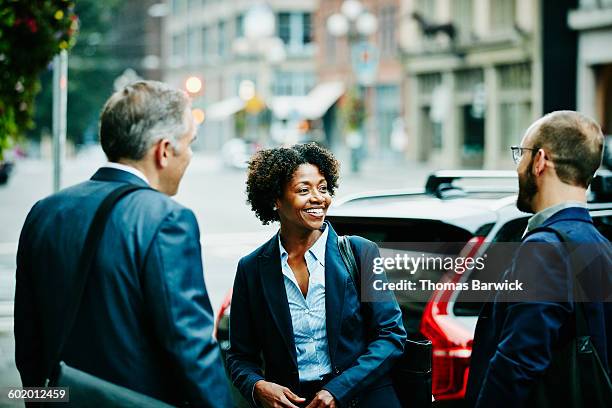 smiling colleagues in discussion on sidewalk - conversation car bildbanksfoton och bilder