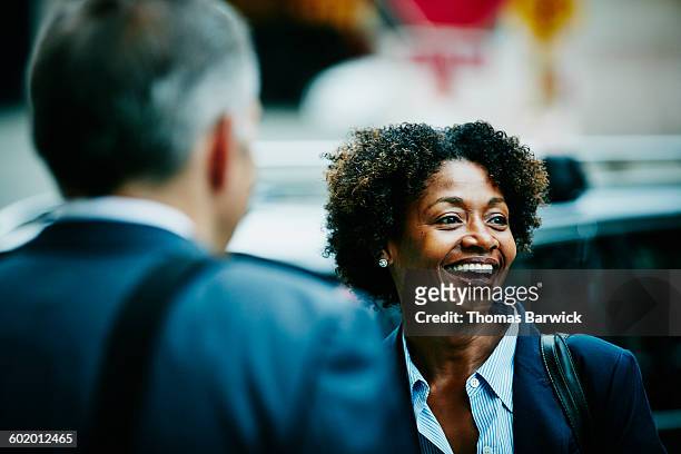 businesswoman in discussion with colleague - woman in black suit stock pictures, royalty-free photos & images