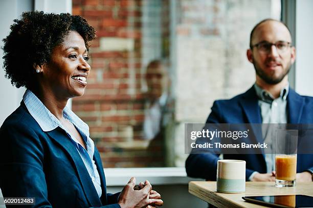 businesswoman in meeting with colleagues in cafe - food and drink establishment stock pictures, royalty-free photos & images