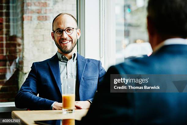 businessman in discussion with colleagues in cafe - männer über 30 stock-fotos und bilder