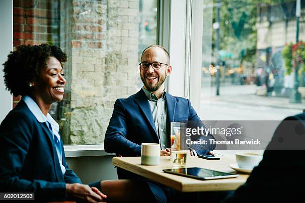 laughing colleagues in discussion in cafe - business meeting customer service stock pictures, royalty-free photos & images