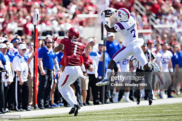 Xavier Woods of the Louisiana Tech Bulldogs intercepts a pass in front of Jared Cornelius of the Arkansas Razorbacks at Razorback Stadium on...