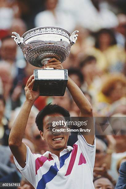 Michael Chang of the United States holds aloft the trophy after winning the Men's Singles Final against Stefan Edberg at the French Open Tennis...