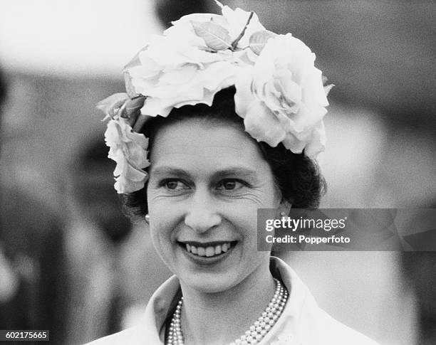 Queen Elizabeth II wearing a hat trimmed with roses on her arrival in Dacca during a Commonwealth visit to East Pakistan , 16th February 1961.