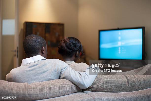 young couple watching tv, cape town, south africa - watching tv rear view stock pictures, royalty-free photos & images