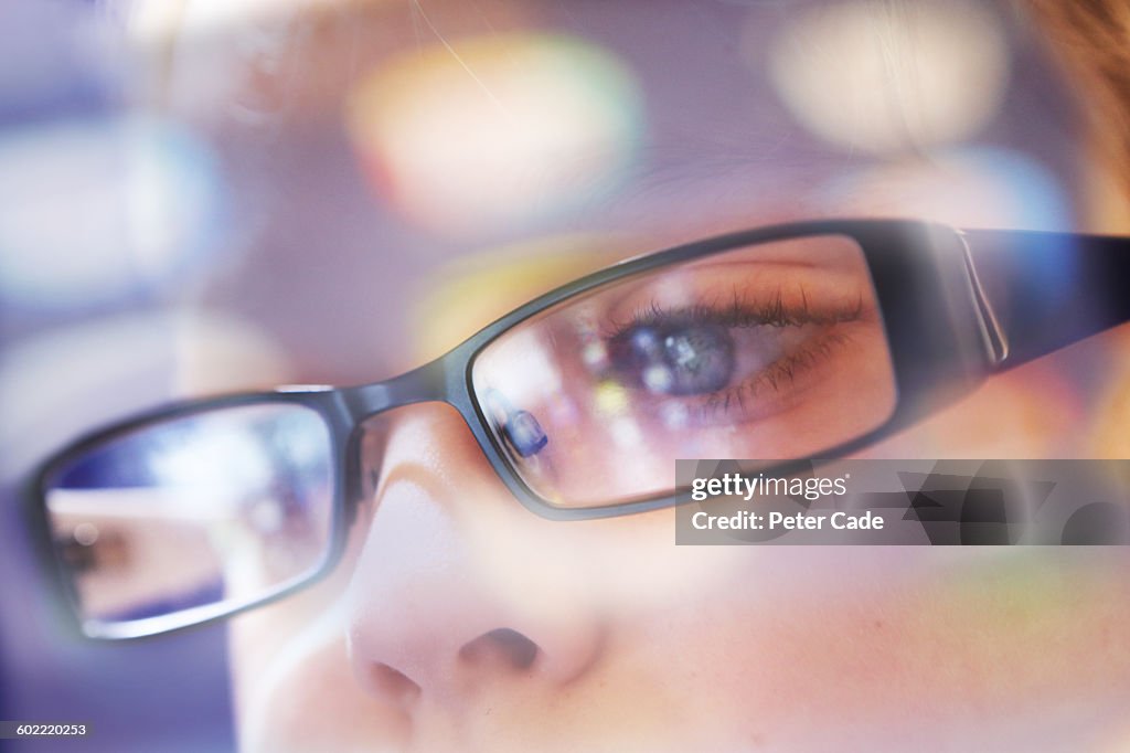 Child, computer/table/phone reflections in glasses