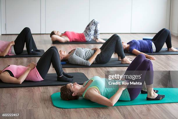 pilates class - lying on back stock pictures, royalty-free photos & images