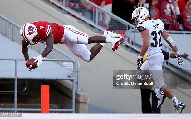 Bradrick Shaw of the Wisconsin Badgers dives into the endzone to score a touchdown past Zach Guiser of the Akron Zips in the fourth quarter at Camp...