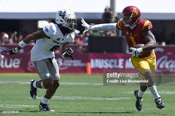 Darreus Rogers of the USC Trojans advances the ball in the 2nd quarter against Wesley Bailey of the Utah State Aggies at Los Angeles Coliseum on...