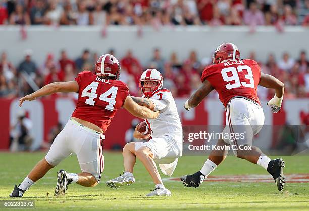 Tyler Ferguson of the Western Kentucky Hilltoppers prepares to be sacked by Dakota Ball and Jonathan Allen of the Alabama Crimson Tide at...