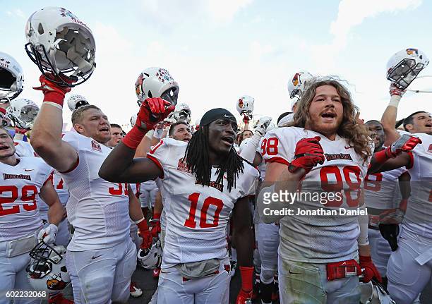 Bryce Holm, Davontae Harris and Dalton Keene of the Illinois State Redbirds celebrate after a win against the Northwestern Wildcats at Ryan Field on...