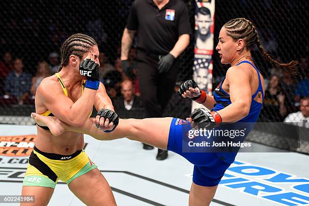 Jessica Eye lands a kick to the body of Bethe Correia of Brazil in their women's bantamweight bout during the UFC 203 event at Quicken Loans Arena on...