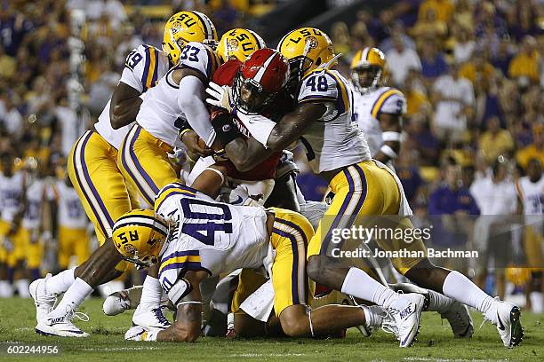 Eli Jenkins of the Jacksonville State Gamecocks is tackled by Jamal Adams and Donnie Alexander of the LSU Tigers during the first half of a game at...