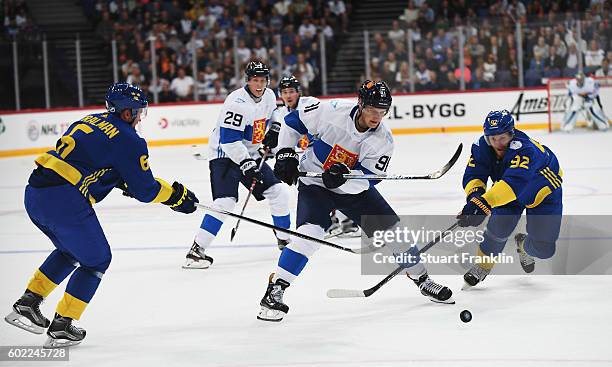 Anton Stralman and Gabriel Landeskog of Sweden are challenged by Aleksander Barkov of Finland during the World Cup of Hockey game between Finland and...