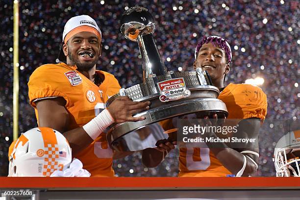 Defensive end Derek Barnett and defensive back Justin Martin of the Tennessee Volunteers celebrate with the trophy following their victory against...
