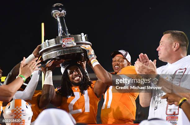 Linebacker Jalen Reeves-Maybin and quarterback Joshua Dobbs of the Tennessee Volunteers celebrate with the trophy following their victory against the...